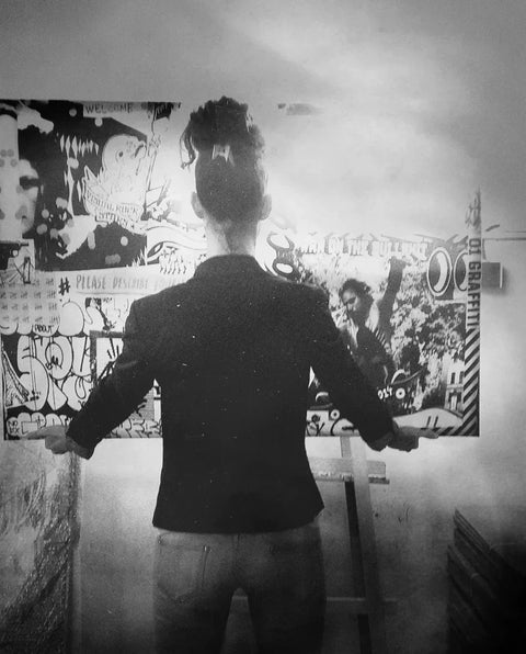 Silhouette of a person with arms outstretched in front of a graffiti wall in Lem’s collection.