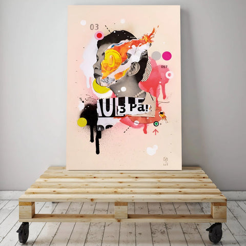 Abstract mixed-media artwork featuring a colorful, fragmented portrait with text elements displayed on a wooden pallet.