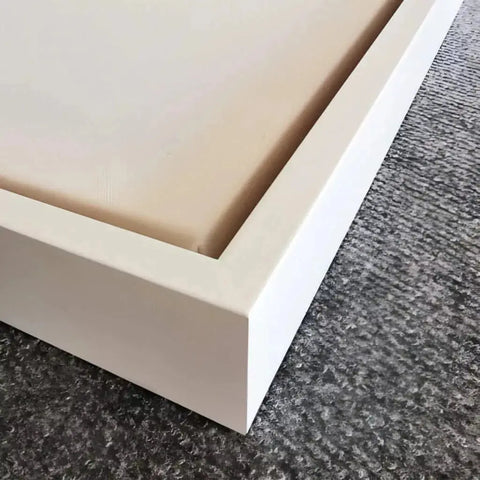 A white bed frame with a white base