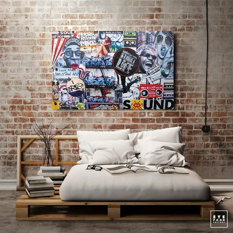 Colorful street art-style collage canvas featuring pop culture imagery and text above a bed.