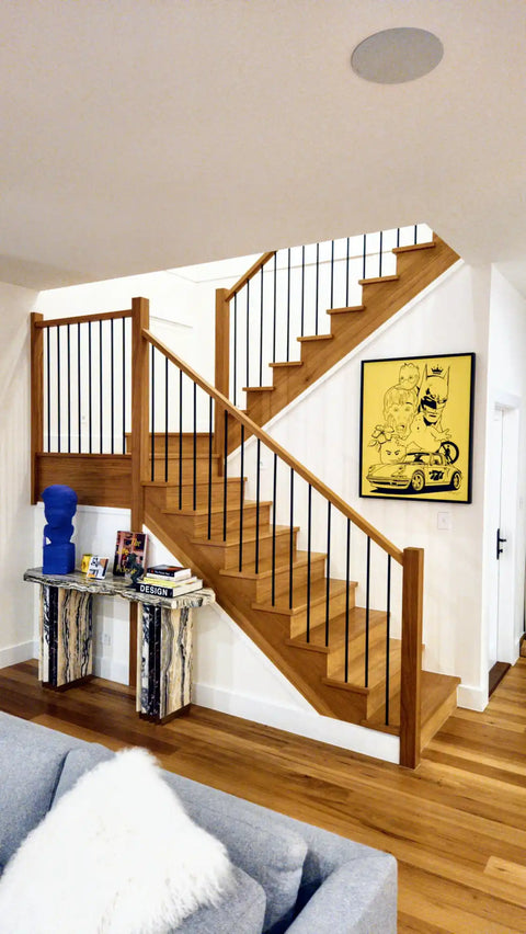 Wooden staircase with white spindles and a polished handrail.